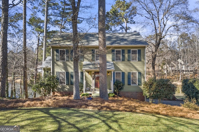 colonial-style house featuring a front lawn