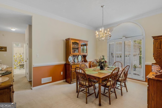 carpeted dining room featuring crown molding and a notable chandelier