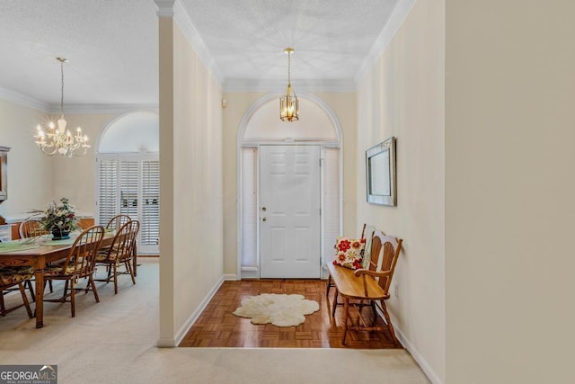 entrance foyer featuring a notable chandelier, crown molding, and a textured ceiling