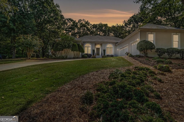 view of front of house featuring a garage and a yard