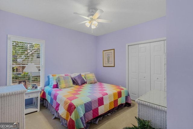 carpeted bedroom featuring ceiling fan and a closet