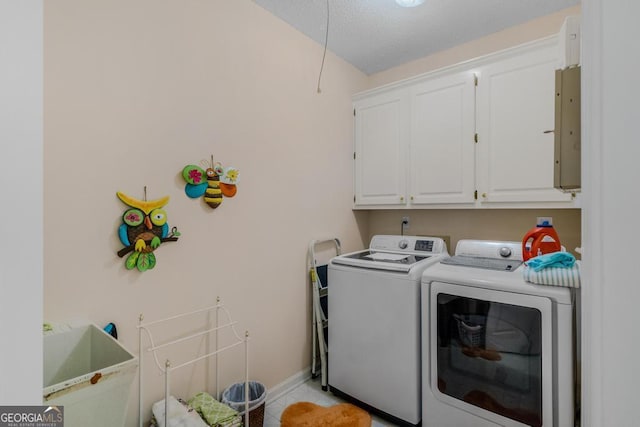 laundry room with cabinets, electric panel, washer and dryer, and a textured ceiling