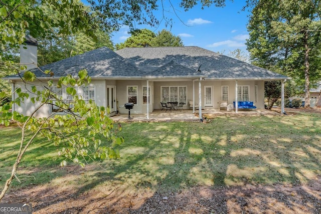 rear view of house featuring a yard and a patio