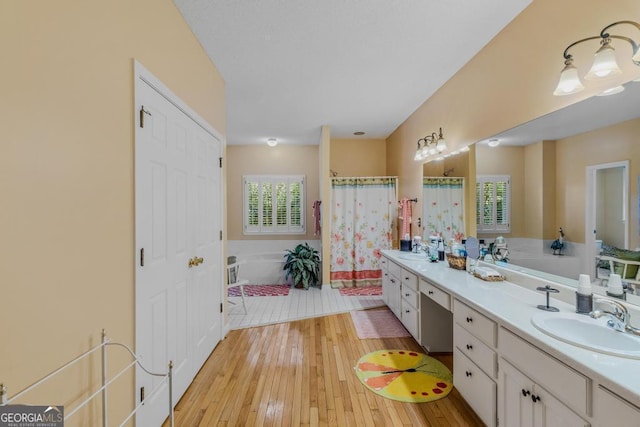 bathroom with vanity, independent shower and bath, and hardwood / wood-style floors