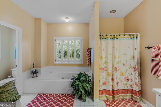 bathroom featuring tile patterned flooring, vanity, a bathtub, and toilet