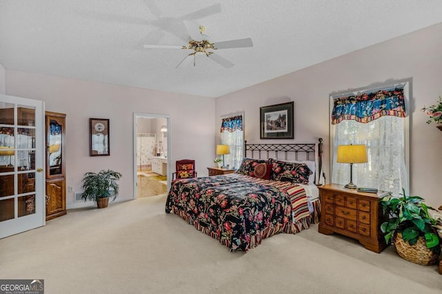 carpeted bedroom featuring ensuite bathroom, a textured ceiling, and ceiling fan