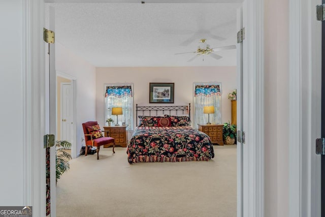 carpeted bedroom featuring a textured ceiling and ceiling fan