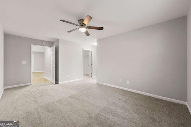 spare room featuring light colored carpet and ceiling fan