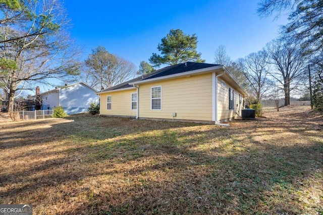 view of property exterior with cooling unit and a yard