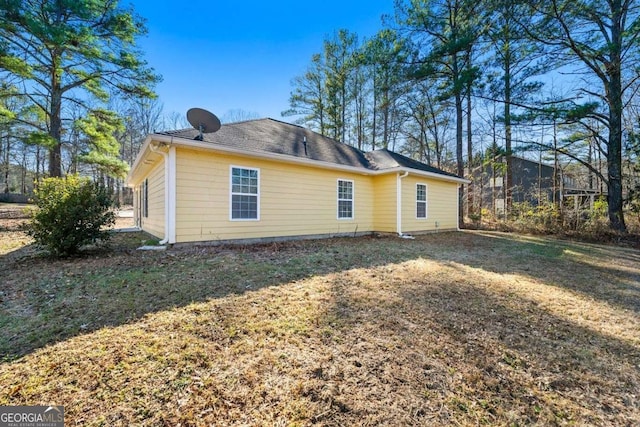 rear view of property featuring a yard