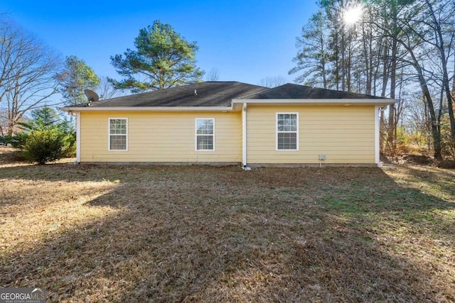 rear view of house featuring a lawn