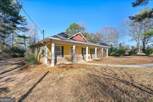 farmhouse-style home featuring covered porch and a front lawn