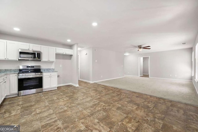 kitchen featuring ceiling fan, appliances with stainless steel finishes, carpet flooring, and white cabinets