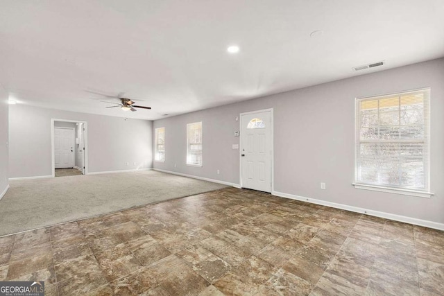 interior space featuring ceiling fan and carpet