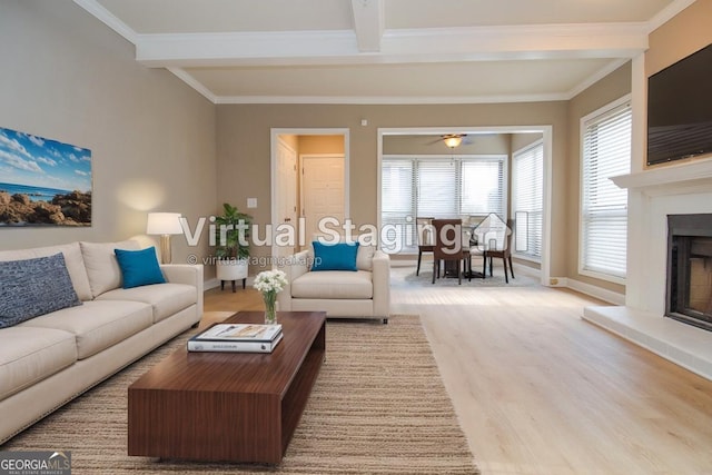 living room with ornamental molding, light wood-type flooring, and beam ceiling