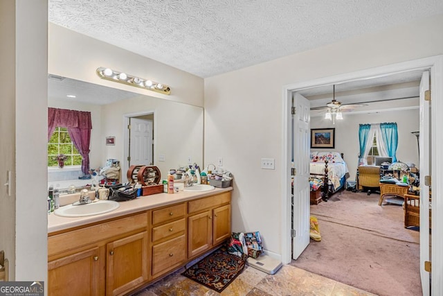 bathroom with vanity, ceiling fan, and a textured ceiling