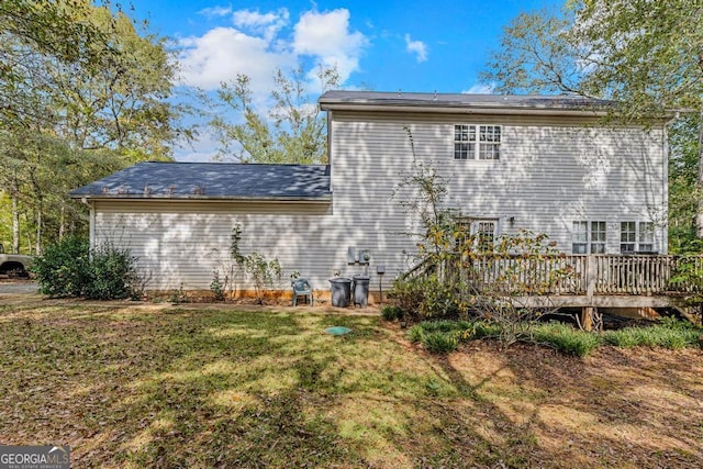 back of property featuring a yard and a deck