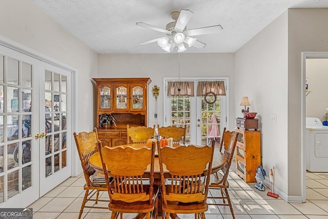 dining area featuring french doors, washer / clothes dryer, a textured ceiling, and light tile patterned floors