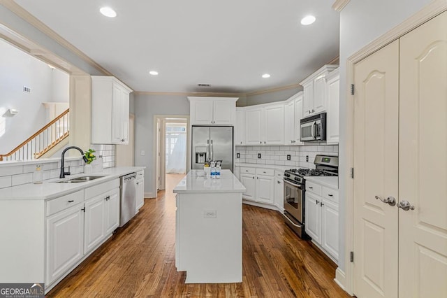 kitchen featuring a kitchen island, appliances with stainless steel finishes, sink, white cabinets, and dark hardwood / wood-style flooring