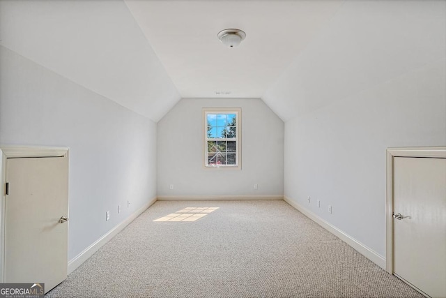 additional living space with light carpet and vaulted ceiling