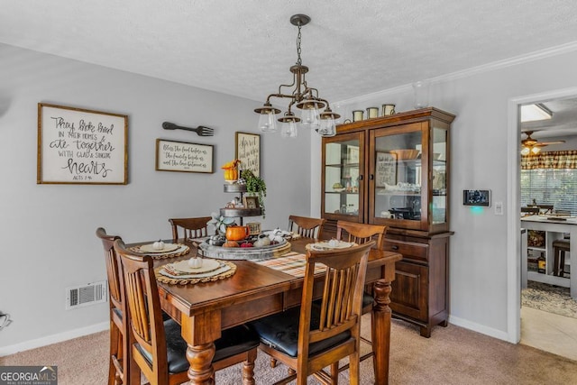 dining room featuring ceiling fan with notable chandelier, light colored carpet, and a textured ceiling