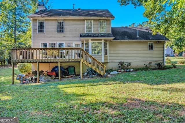 rear view of property featuring a lawn and a deck