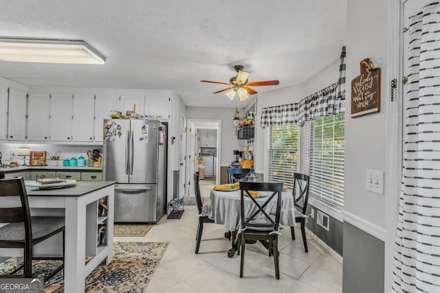 dining space with ceiling fan and light tile patterned flooring