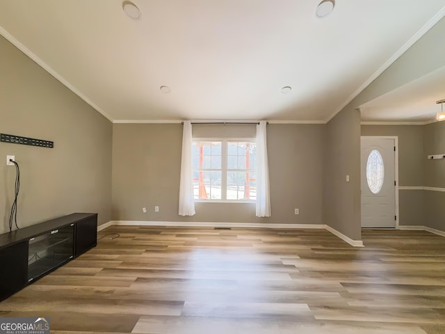 entryway featuring crown molding, lofted ceiling, and light hardwood / wood-style floors