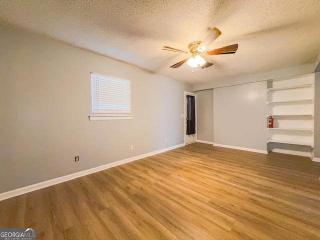 empty room with hardwood / wood-style flooring, ceiling fan, and a textured ceiling