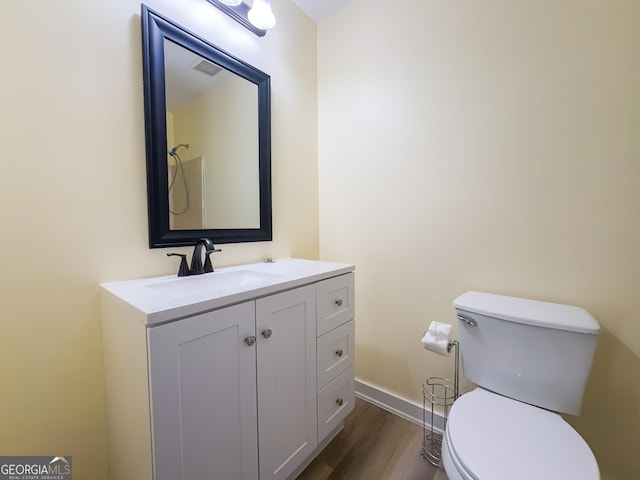 bathroom with vanity, wood-type flooring, and toilet