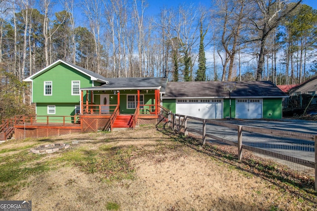 tri-level home featuring a garage, covered porch, and a front lawn