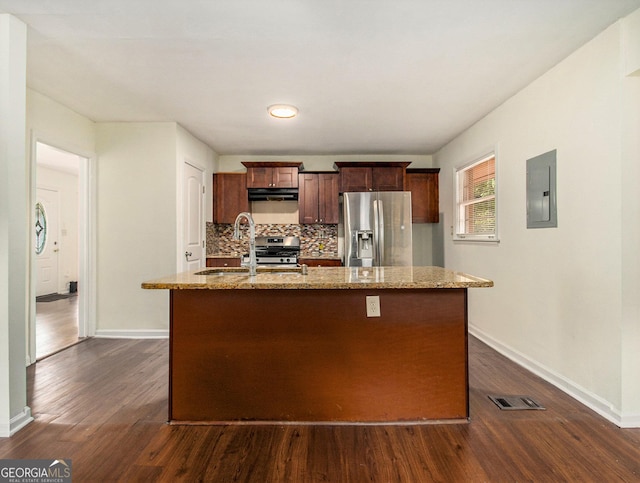 kitchen with sink, tasteful backsplash, appliances with stainless steel finishes, electric panel, and a kitchen island with sink