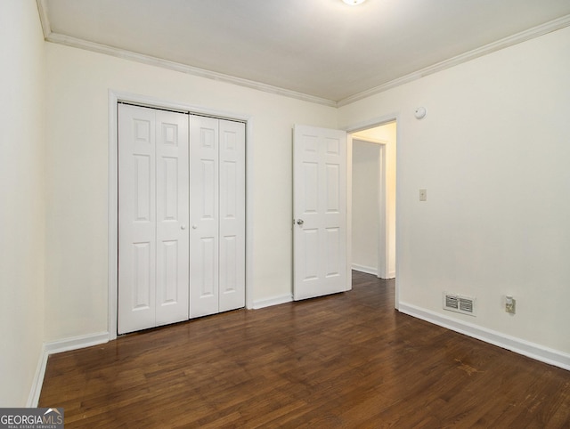 unfurnished bedroom featuring a closet, crown molding, and dark hardwood / wood-style floors