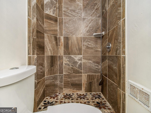 bathroom with toilet and tiled shower