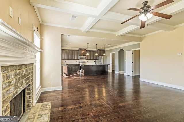 living room with ornamental molding, coffered ceiling, ceiling fan, dark wood-type flooring, and beam ceiling