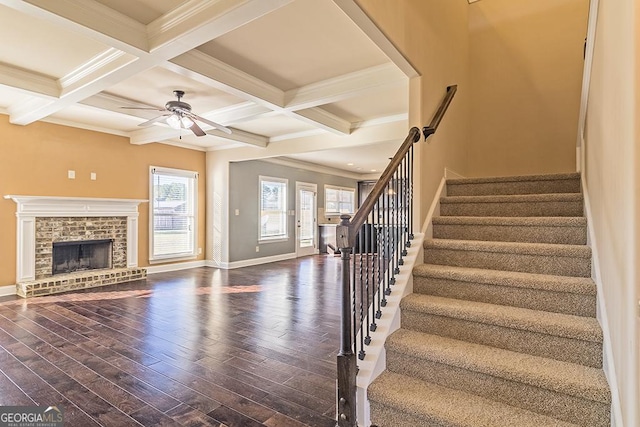 living room featuring a fireplace, ornamental molding, dark hardwood / wood-style flooring, and beam ceiling