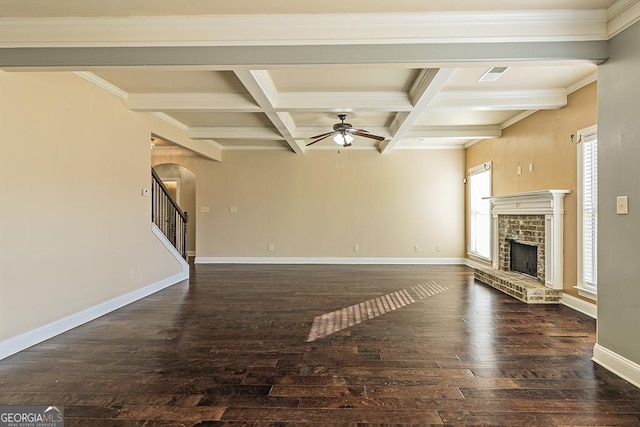 unfurnished living room with coffered ceiling, a brick fireplace, dark wood-type flooring, and beamed ceiling