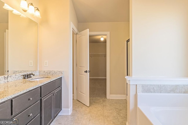 bathroom featuring vanity, tile patterned flooring, and a tub