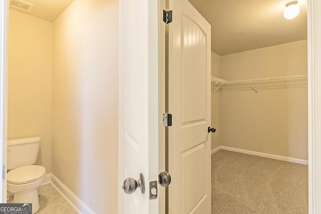 walk in closet featuring light carpet