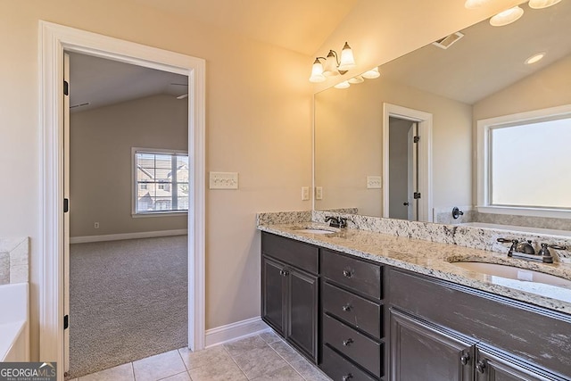 bathroom with vaulted ceiling, vanity, and tile patterned floors