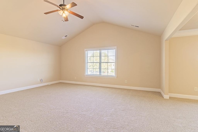 empty room featuring lofted ceiling, ceiling fan, and carpet flooring