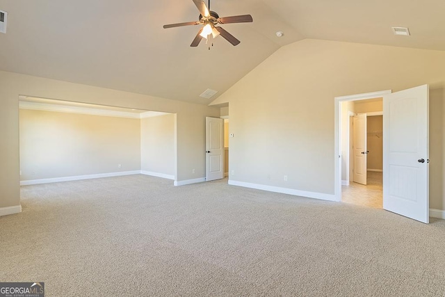 carpeted spare room featuring high vaulted ceiling and ceiling fan