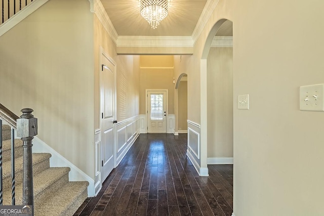 hall featuring ornamental molding, dark hardwood / wood-style floors, and a chandelier