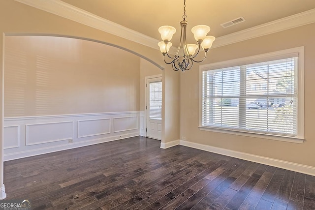 empty room featuring ornamental molding, a notable chandelier, and dark hardwood / wood-style flooring