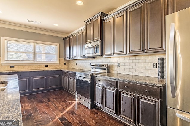 kitchen featuring backsplash, ornamental molding, stainless steel appliances, and stone counters