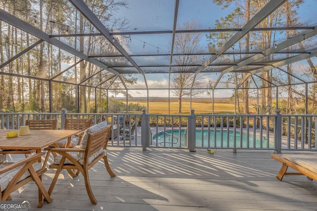 wooden deck with a fenced in pool and a lanai