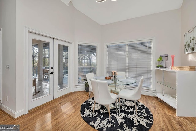 dining area with baseboards, french doors, a healthy amount of sunlight, and light wood-style floors