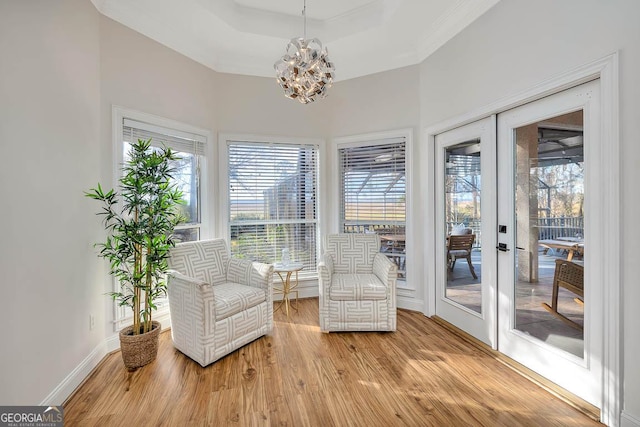 sunroom / solarium featuring a chandelier, a tray ceiling, and french doors