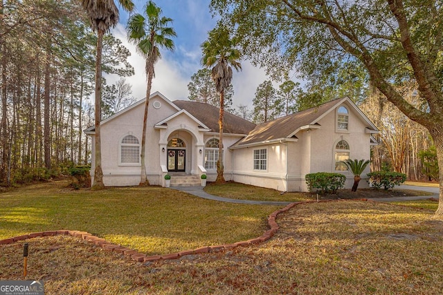 view of front of home featuring french doors, a front lawn, and stucco siding