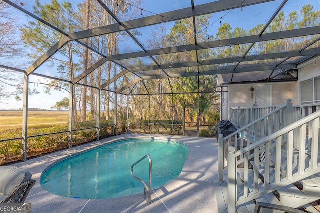 pool with a lanai and a patio area